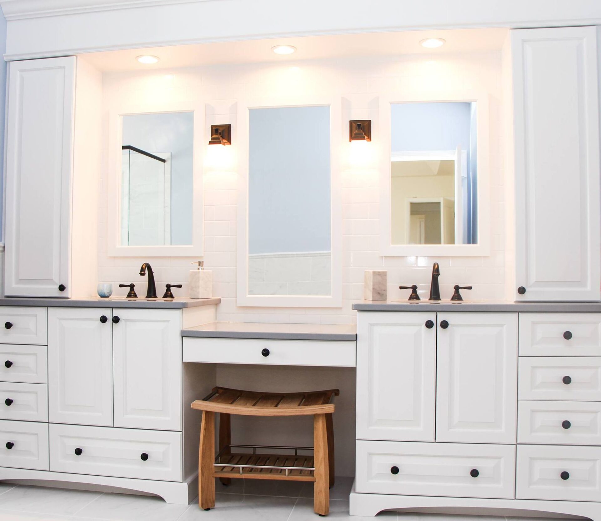 A modern bathroom featuring white cabinets and a stylish bench for seating and convenience. A modern bathroom featuring white cabinets and a stylish bench for seating and convenience.